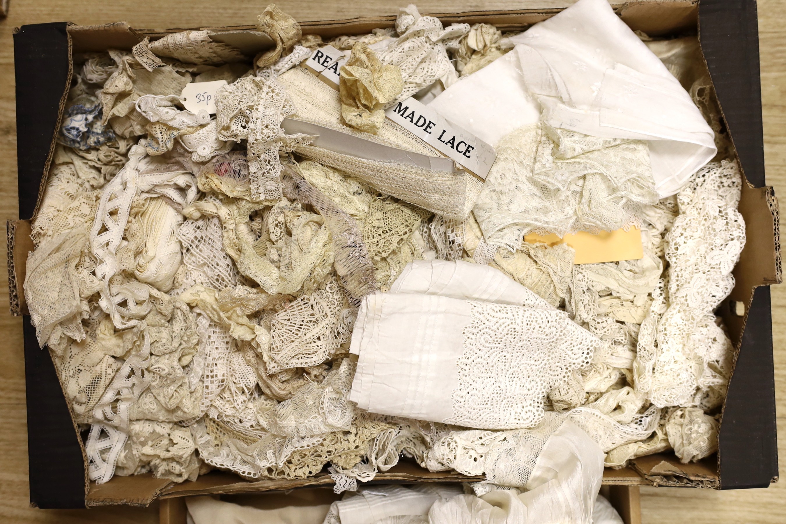 A quantity of mixed machine and some handmade lace including Irish crochet, together with a white work petticoat, silk christening gown and a silk shawl